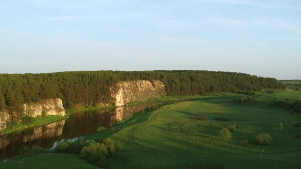 Aerial View of the River with a Rock and Forest on the Banks