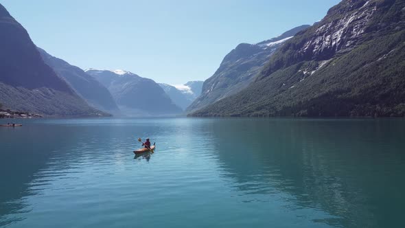 Kayaking in spectacular surroundings at Lovatnet lake Loen Nordfjord Norway - Static aerial with gir