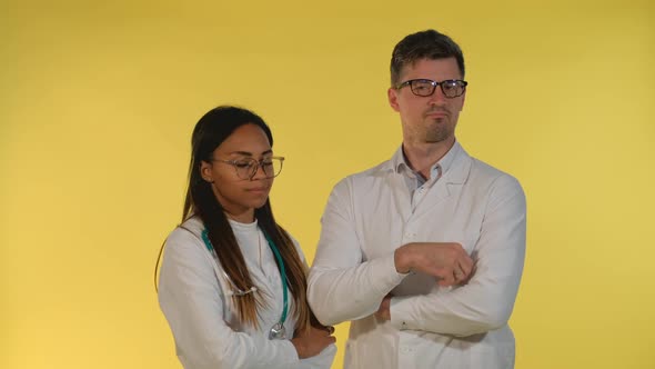 Diverse Doctors in Lab Coats and Eyeglasses Denying Something on Yellow Background