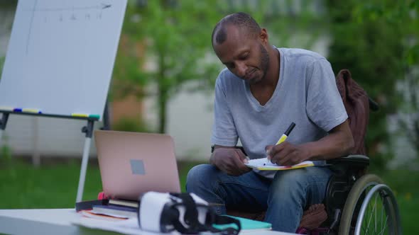 Portrait of Paraplegic African American Man Writing Idea in Sketchpad Thinking