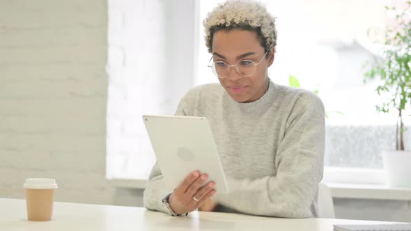 African Woman Making Video Call on Tablet in Office