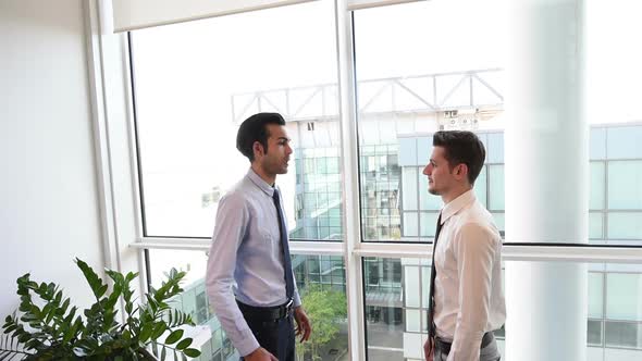 slow motion two young businessman indoor office interior shaking hands