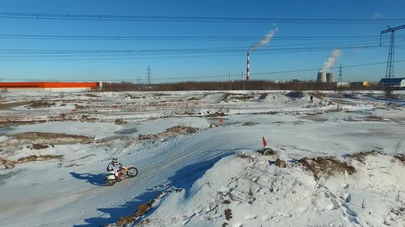 a motorcyclist performs stunts on a winter track