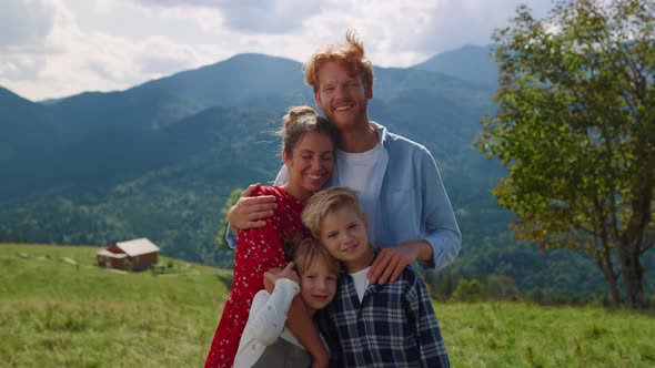 Smiling Family Standing Hill Cuddling Close Up