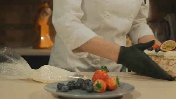 the Pastry Chef Prepares a Meringue Roll with Cream and Fruit and Takes Dessert To the Client