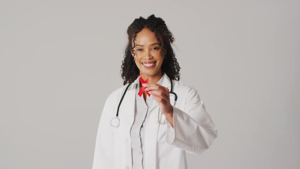 Video of smiling biracial female doctor holding orange kidney cancer ribbon