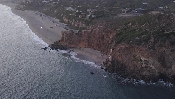 AERIAL: Flight Over Malibu, California View of Beach Shore Line Pacific Ocean at Sunset with