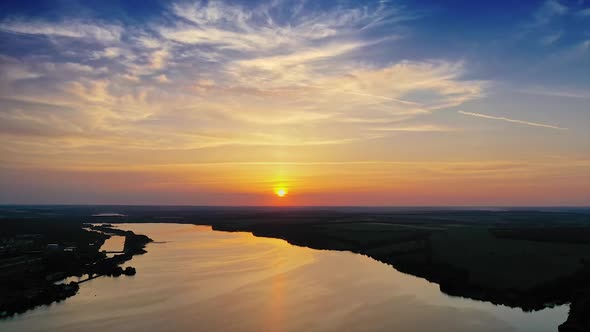 Aerial view of huge river against sunset. Aerial view of landscape of rural countryside at sunset