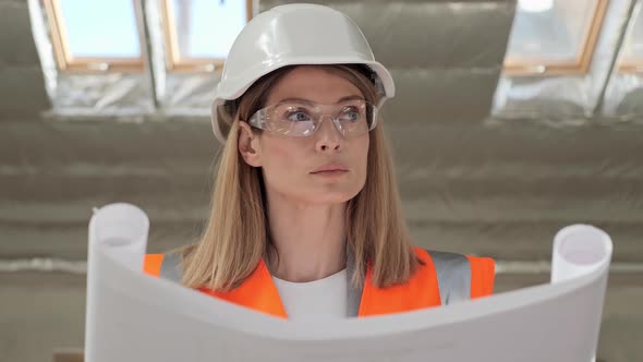 Portrait of Thoughtful Female Architect Analyzing Blueprint in Empty Building