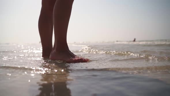 Slim Woman with Beautiful Legs in a Swimsuit Walks Along the Beach Persian Gulf