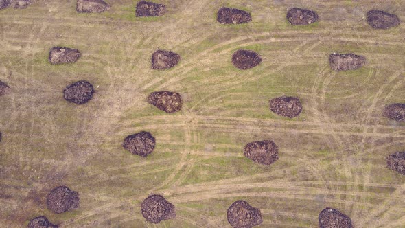 Manure Heaps Scattered Across a Farm Field Aerial View