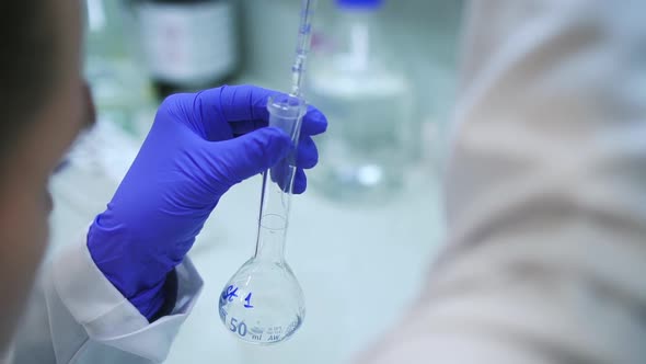 Scientist Dripping Liquid Into Test Tube Flask Spbd