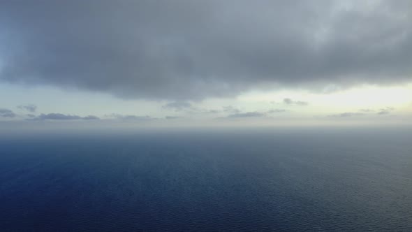 Still Ocean Waters and Heavy Clouds in Background