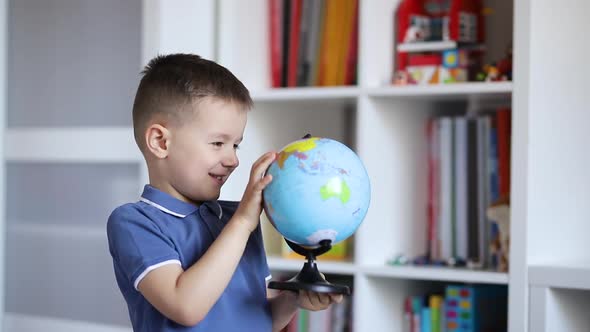 A child examines a globe while holding it in his hands