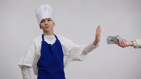 Little Chef Taking Bribe Cash Hiding Money in Pocket Standing at White Background