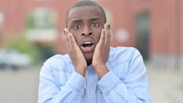 Outdoor Portrait of Young African Man Reacting to Loss Failure