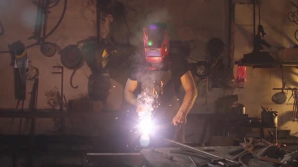 Welder Working a Welding Metal with Protective Mask and Sparks. Slow Motion