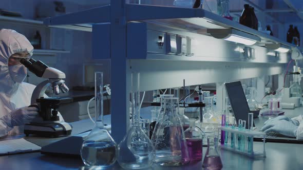 Scientists in Protective Coveralls Working in Laboratory