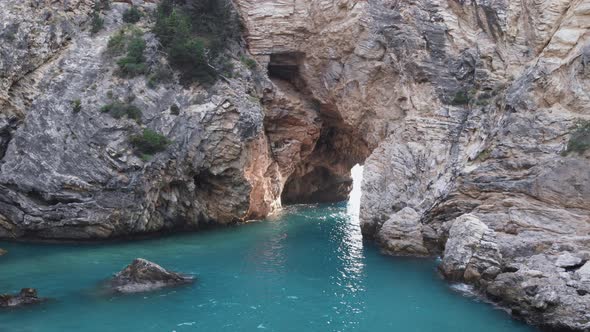 Blue ocean waves viewed though natural rock archway