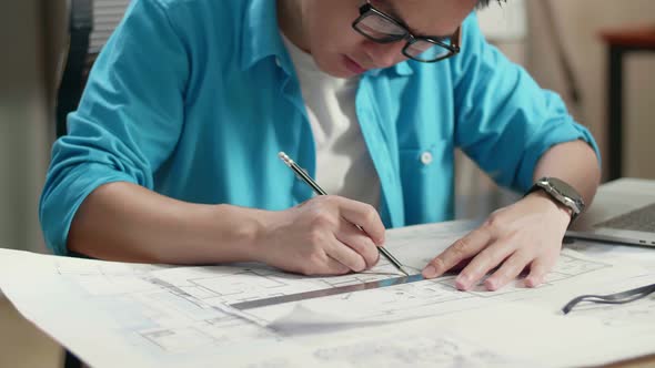 Close Up Of Asian Man Engineer With A Laptop Drawing Blueprint At The Office alt