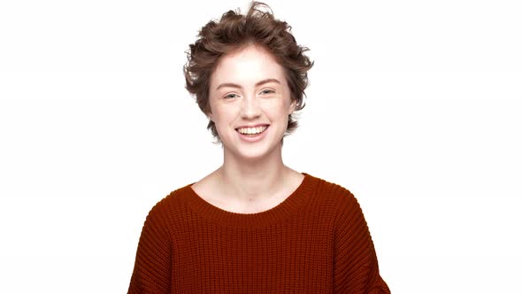 Portrait of Caucasian Female in Red Sweater Laughing on Camera Being in Good Mood Isolated Over