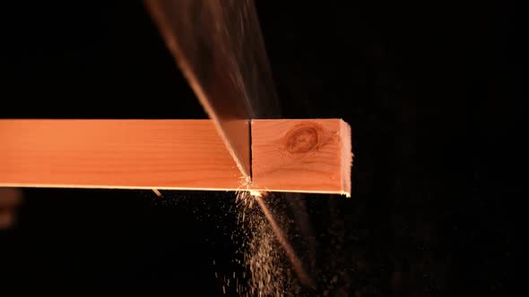 Man Carpenter Saws a Wooden Board with a Hand Saw