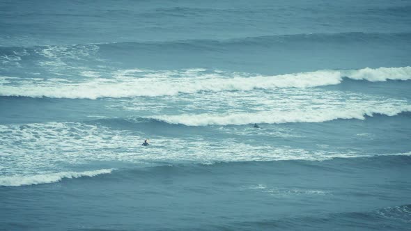 Surfers Catching Waves Out At Sea