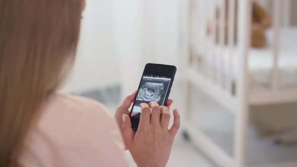 Woman Looking At Baby Ultrasound Image