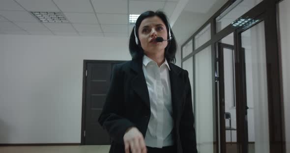 Businesswoman Phoning with Headset in Office Corridor