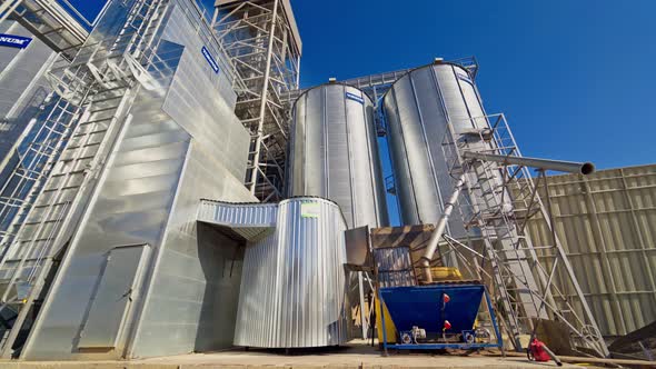 Commercial Grain Or Seed Silos In Sunny Spring Rural Landscape