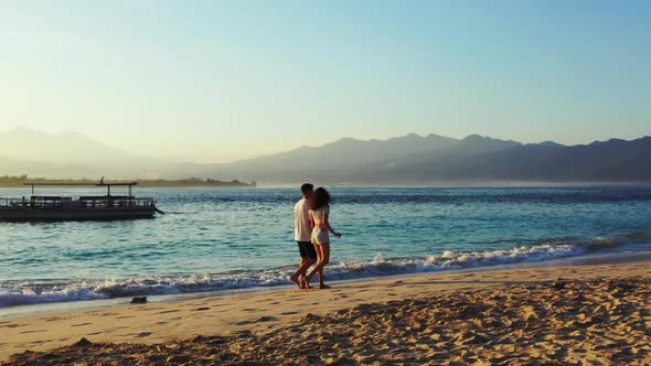 Teenage lovers relax on exotic coastline beach wildlife by blue ocean with white sand background of 