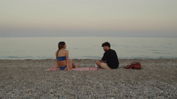 Young Couple Talking on the Sea Shore