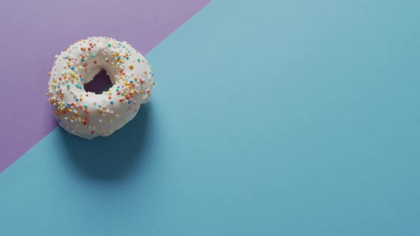 Video of donuts with icing on blue and purple background