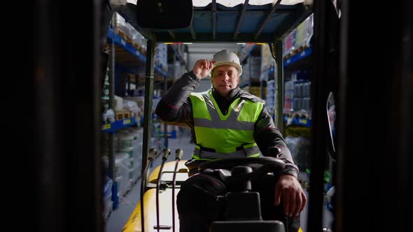 Front View Portrait of Smiling Confident Male Warehouse Loader Adjusting White Hard Hat Looking at