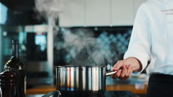 The chef sets fire to the dish in the professional kitchen of the restaurant. The process of cooking