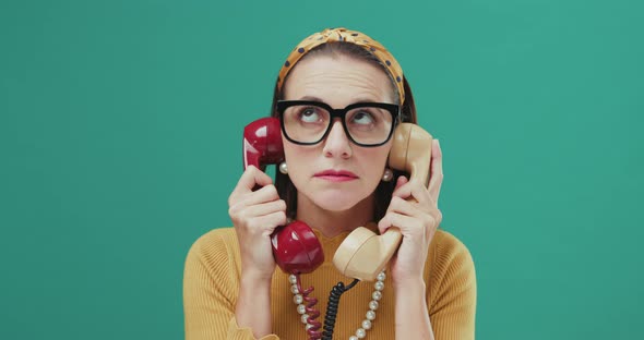 Woman holding two telephone receivers