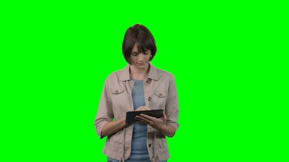 Woman using digital tablet against green background