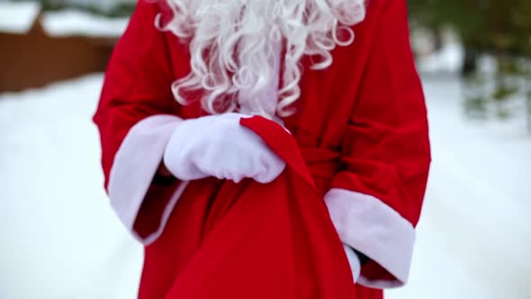 Food delivery service containers in hands of Santa Claus outdoor in snow. Christmas eve promotion. R