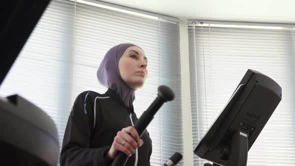 Pretty Girl in Hijab on a Sports Simulator Step