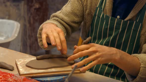 Male potter molding a clay