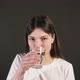 a young girl holds a glass and drinks fresh, clean, filtered mineral water. - VideoHive Item for Sale