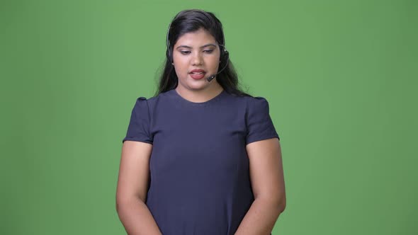 Young Overweight Beautiful Indian Businesswoman Against Green Background