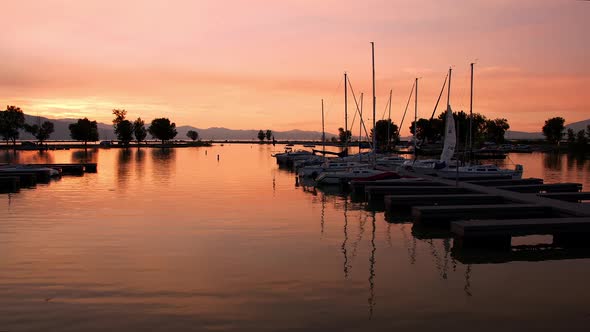 Panning view of boat harbor during colorful sunset at Utah Lake