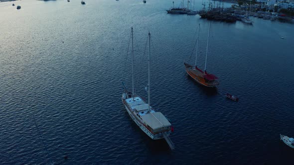 Slow Rising Shot Over Yachts in the Sea Showing Resort Bay with Mountains Against the Sunset