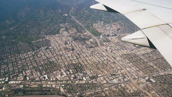 View From Plane Flying Over Houses Buildings And Highway Of Los Angeles City