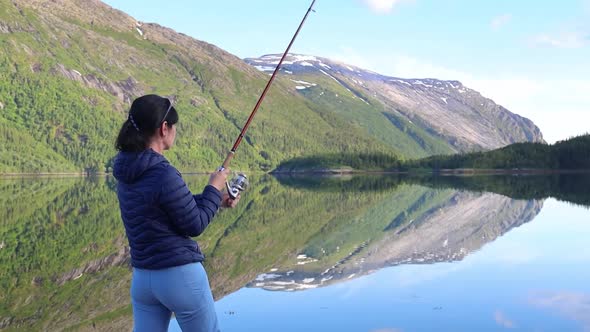 Woman Fishing on Fishing Rod Spinning in Norway