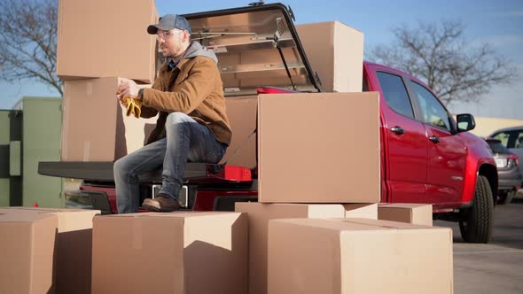 Courier Unloading Shipping Boxes Parcel From His Truck