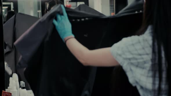 Woman Client Sits Down Into Chair To Have Haircut in Salon