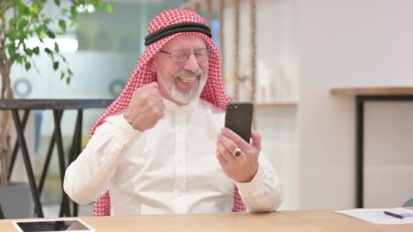 Senior Old Arab Businessman with Success on Smartphone