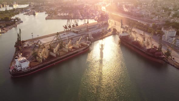 Aerial View of Big Cargo Ship Bulk Carrier is Loaded with Grain of Wheat in Port at Sunset